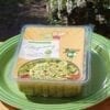 A container of food sitting on top of a green plate.